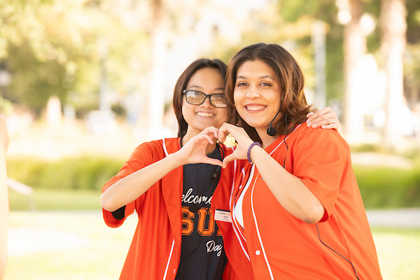 two csuf employees with a heart sign.