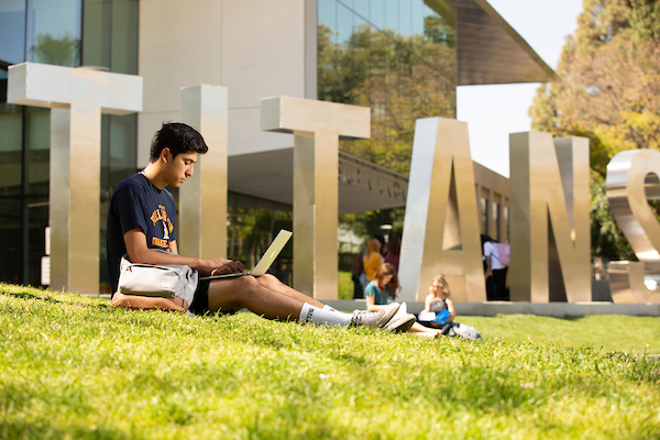 student on laptop outside